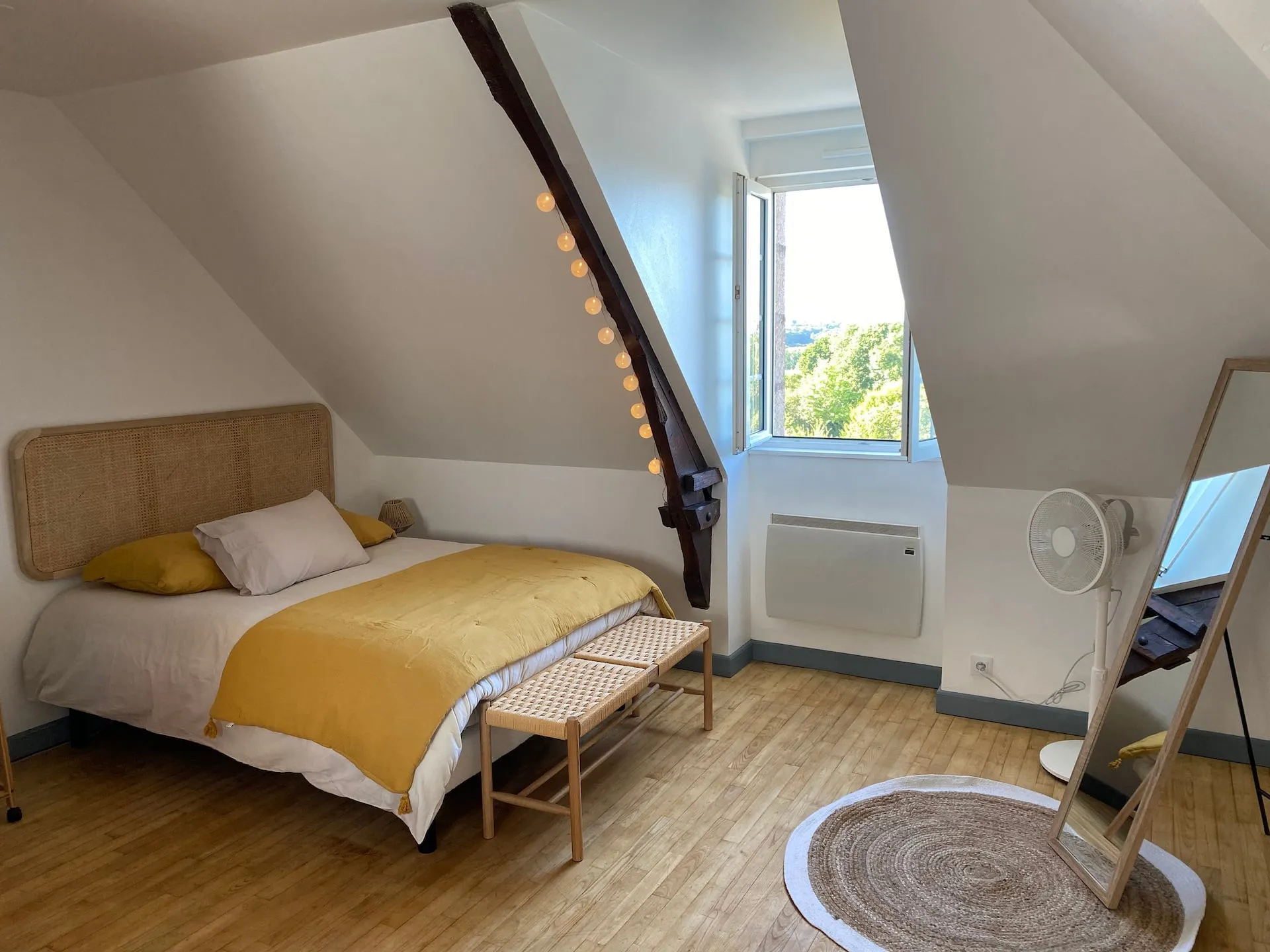 Chambre mansardée baignée de lumière à Saint-Samson-sur-Rance, fenêtre ouverte sur la campagne